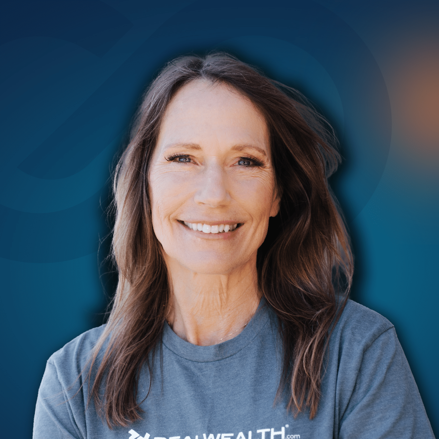 A woman with long brown hair wearing a gray t-shirt is smiling in front of a blue gradient background.