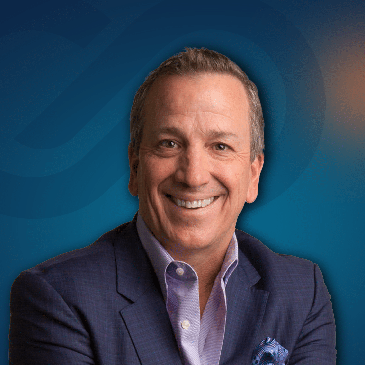 A man in a business suit smiles at the camera, posing against a blue background with abstract design elements.