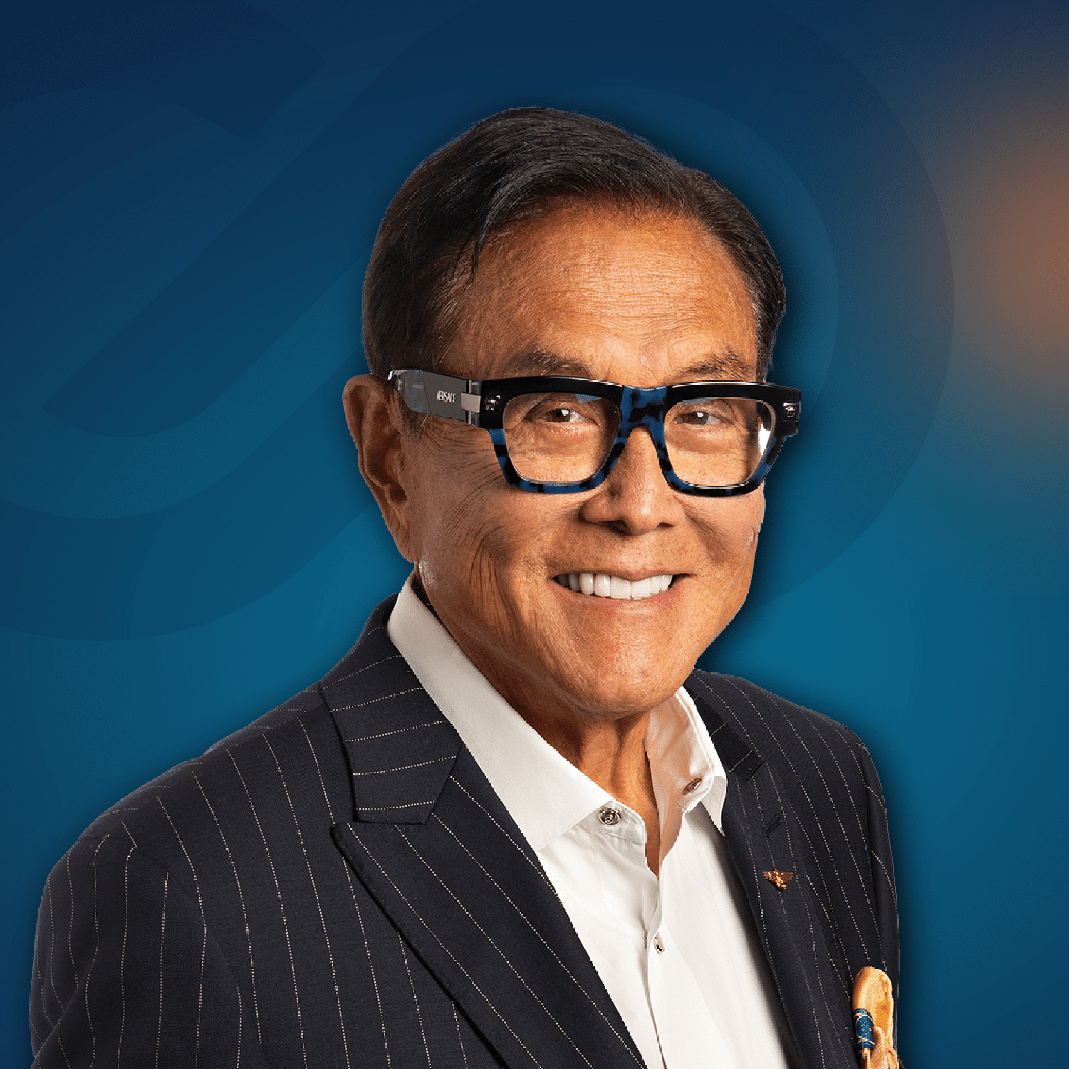 A smiling man wearing glasses, a dark pinstripe suit, a white shirt, and a yellow pocket square, posing in front of a blue gradient background.