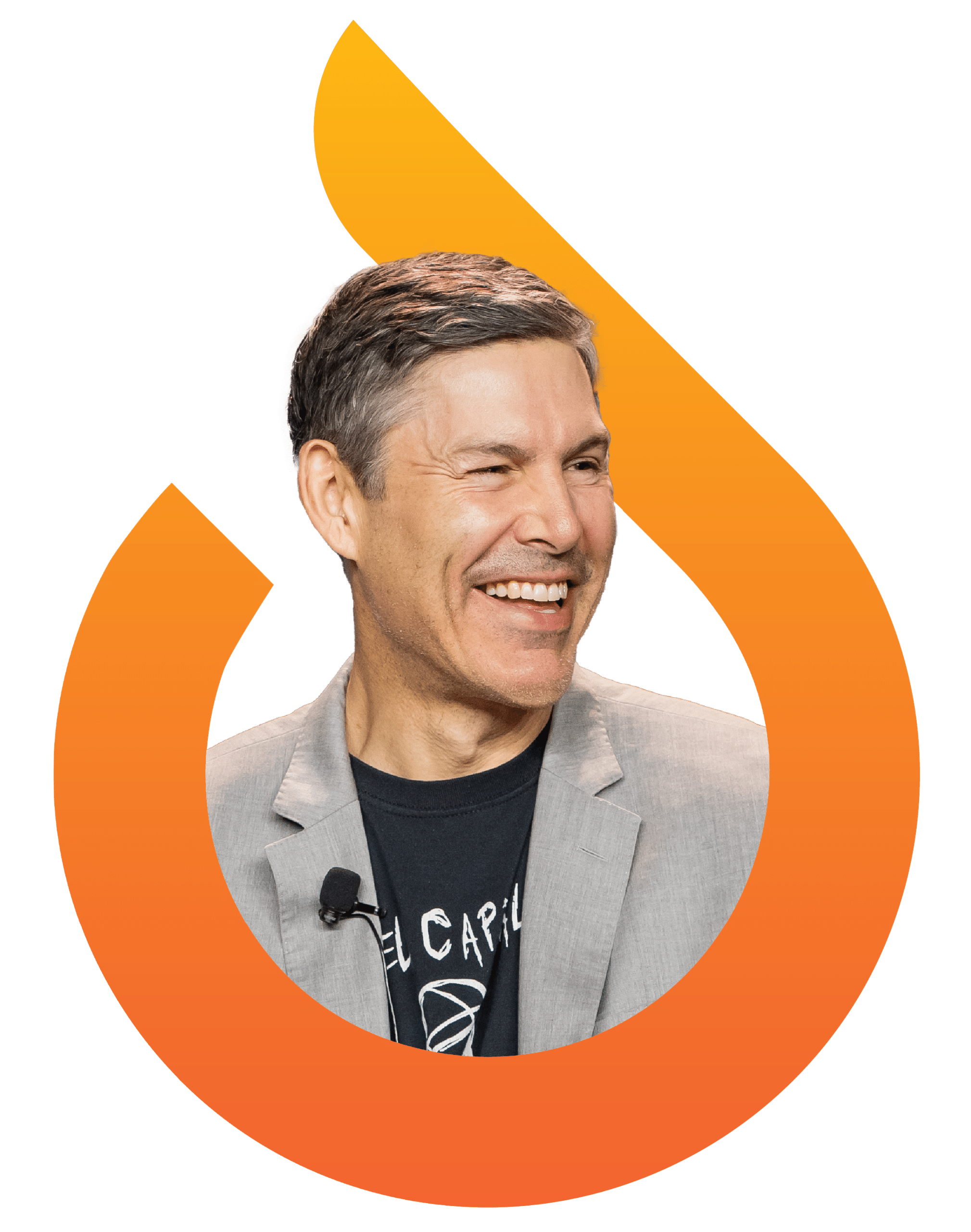 A smiling man in a gray blazer and black t-shirt, wearing a lapel microphone, is framed by an orange flame-shaped graphic.